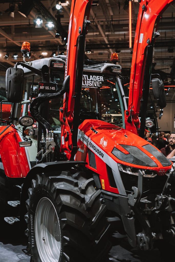 Close-up of a red tractor displayed at an indoor agricultural expo showcasing modern farm machinery.
