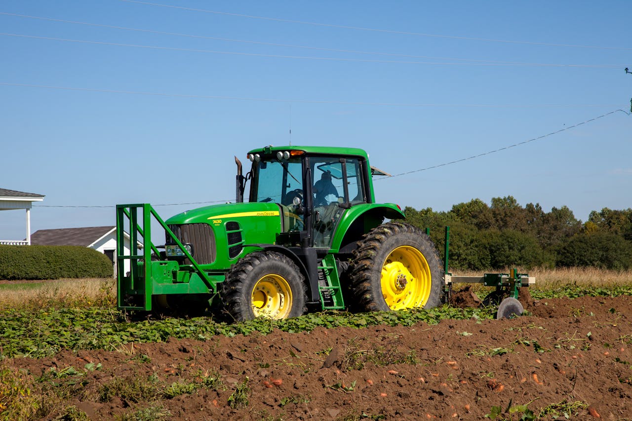 Features A powerful green tractor cultivating a field in rural North Carolina.